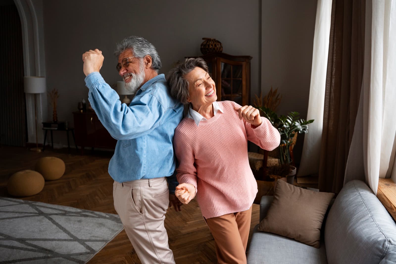 Een ouder echtpaar danst onbezorgd in hun woonkamer